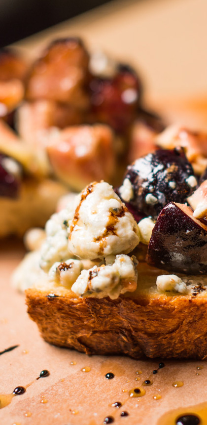 Tempting photo of details from a CRU cheese and fig recipe, highlighting rustic bread edges and oil.