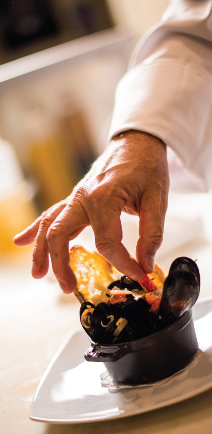 Photo emphasizing the chef's attention to detail while plating a CRU order.