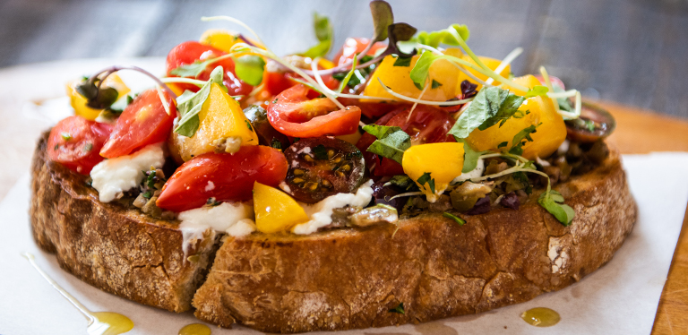 Photo of delicious CRU bruschetta, with a focus on the colorful toppings and rustic bread base.